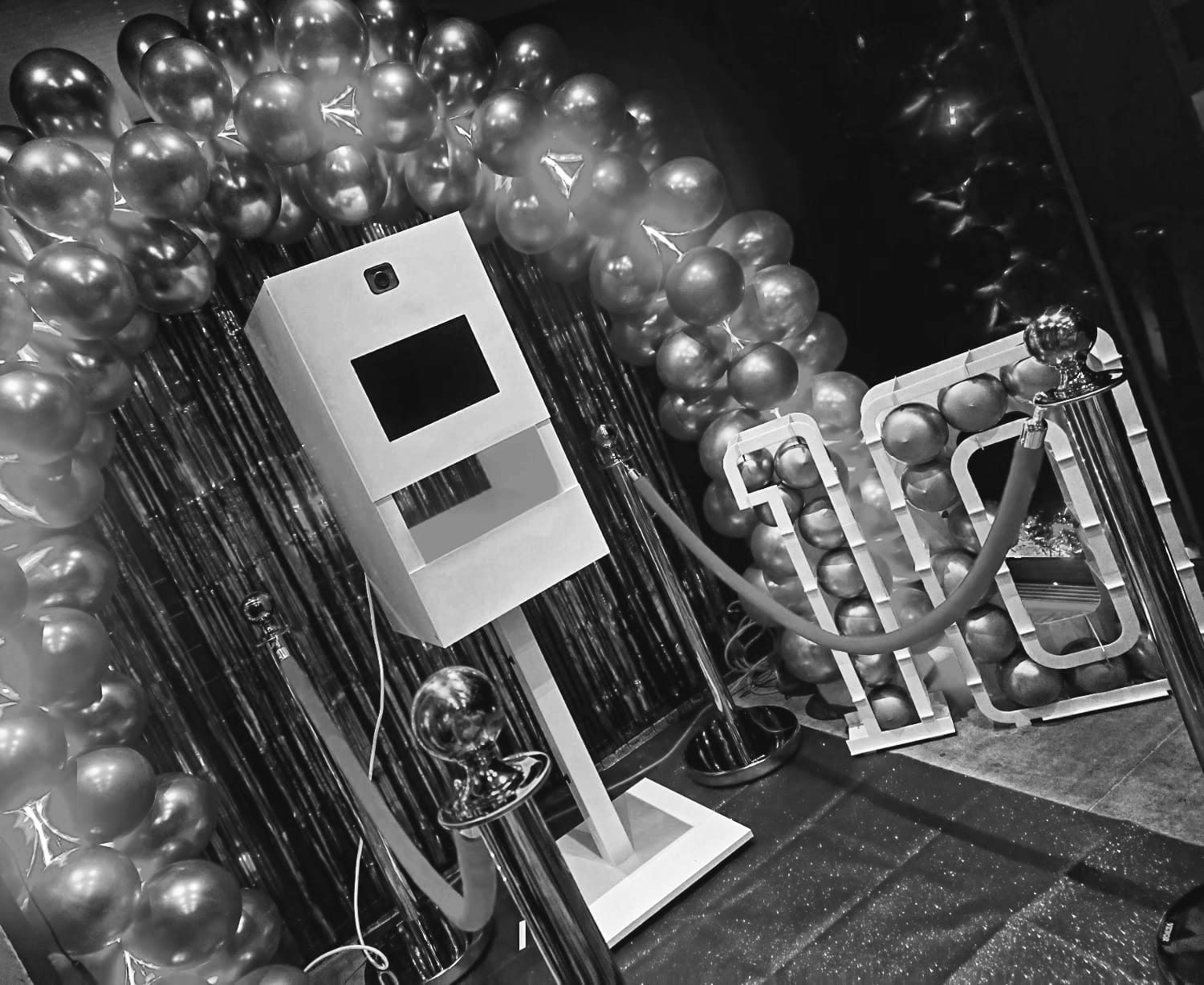 photobooth te huur Fotobooth met feestelijke ballonnen en rode loper in een feestelijke setting.